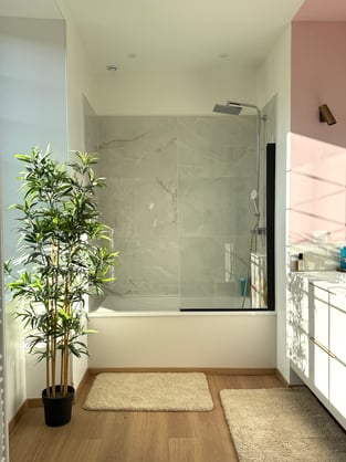  La salle de bain des enfants, tout en douceur — marbre blanc, mur rose poudré et lumière naturelle.