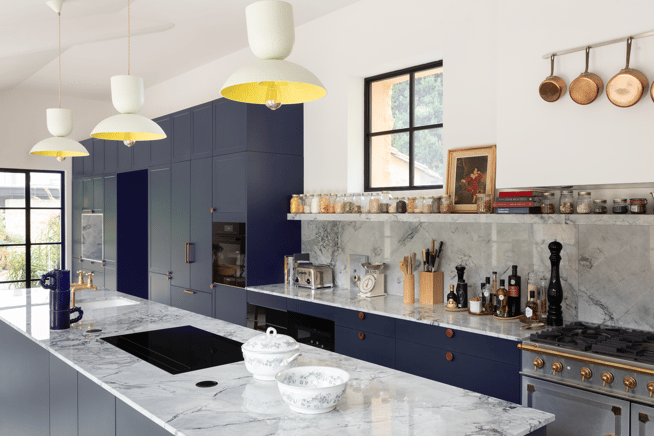 Cuisine sur mesure Perene Réunion avec façades bleu profond, îlot central en marbre, électroménager intégré et finitions haut de gamme.