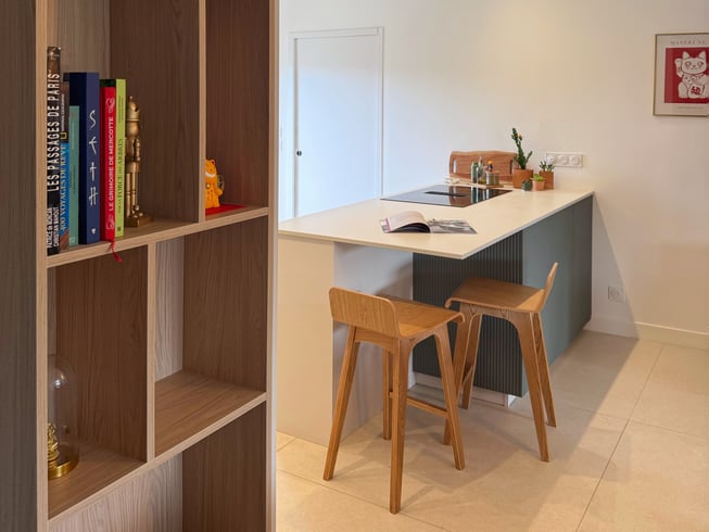 Îlot central avec espace repas et bibliothèque intégrée sur mesure.