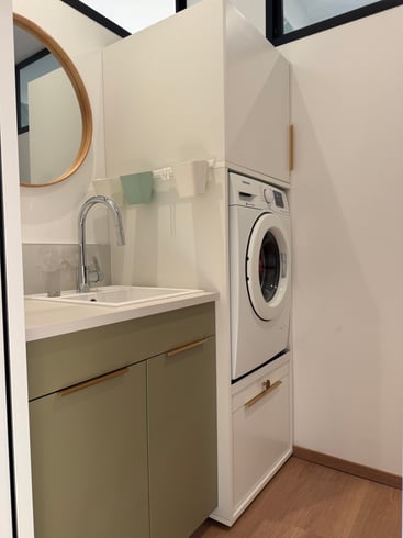 La buanderie intègre le lave-linge dans une colonne sur mesure, sans sacrifier l'esthétique.