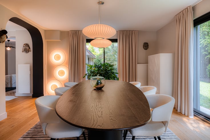 Salle à manger contemporaine avec table en bois massif, arches architecturales, luminaires design et mobilier sur mesure réalisée par PERENE Caen.