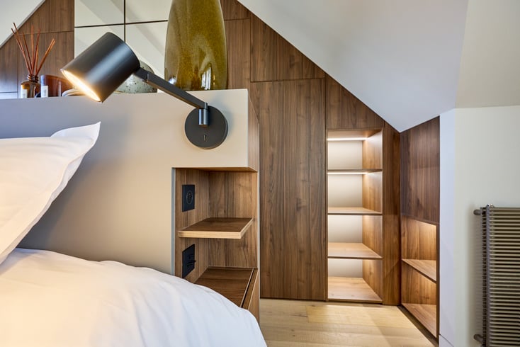 Suite parentale sous pente avec rangements sur mesure et niches intégrées réalisée à Deauville