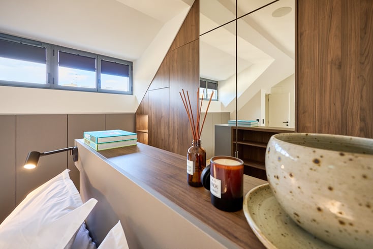 Agencement sur mesure d'une suite parentale avec dressing sous pente et miroir toute hauteur