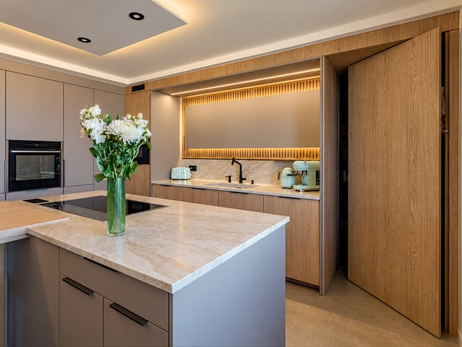 Cuisine contemporaine aux tons naturels, associant bois clair, mobilier épuré et verrière noire. Une grande table centrale, entourée de chaises en cuir cognac, structure l’espace, sublimé par des éclairages indirects chaleureux. Cuisine contemporaine aux tons naturels, associant bois clair, mobilier épuré et verrière noire. Une grande table centrale, entourée de chaises en cuir cognac, structure l’espace, sublimé par des éclairages indirects chaleureux.
