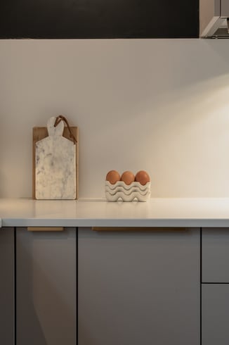 Détail du plan de travail clair, des poignées dorées et des accessoires de cuisine. Détail du plan de travail clair, des poignées dorées et des accessoires de cuisine.