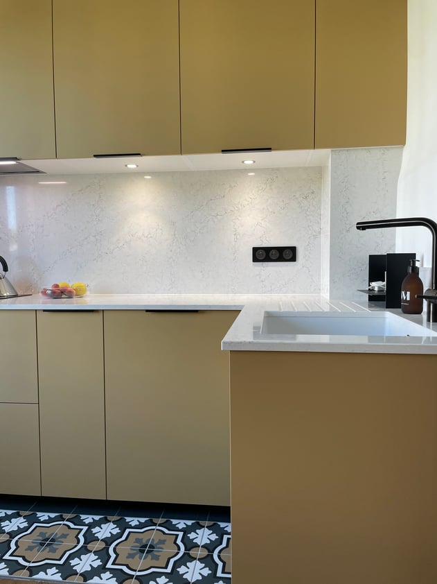 Espace évier en quartz Dakota blanc veiné avec robinetterie noire et éclairage intégré