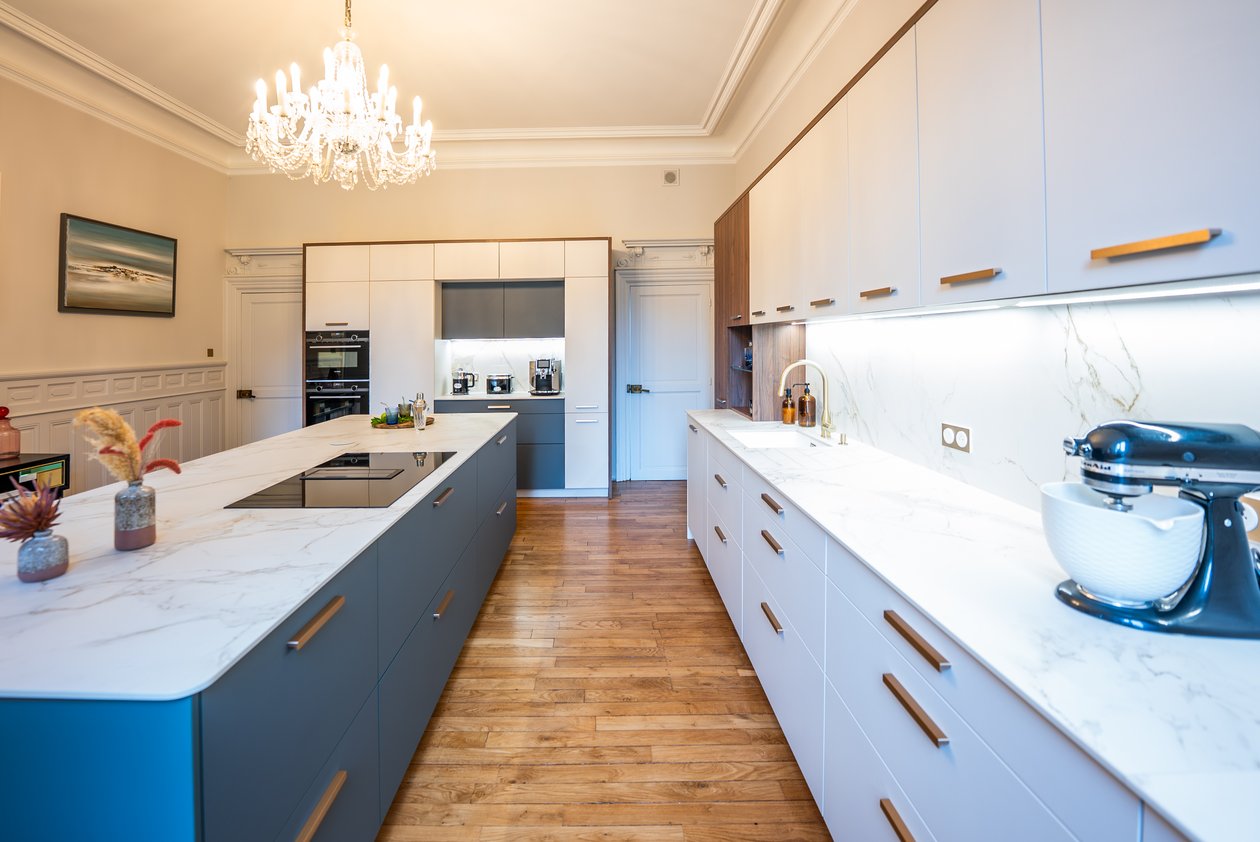 Cuisine avec ilot central vert kaki et mur d'armoire blanc
