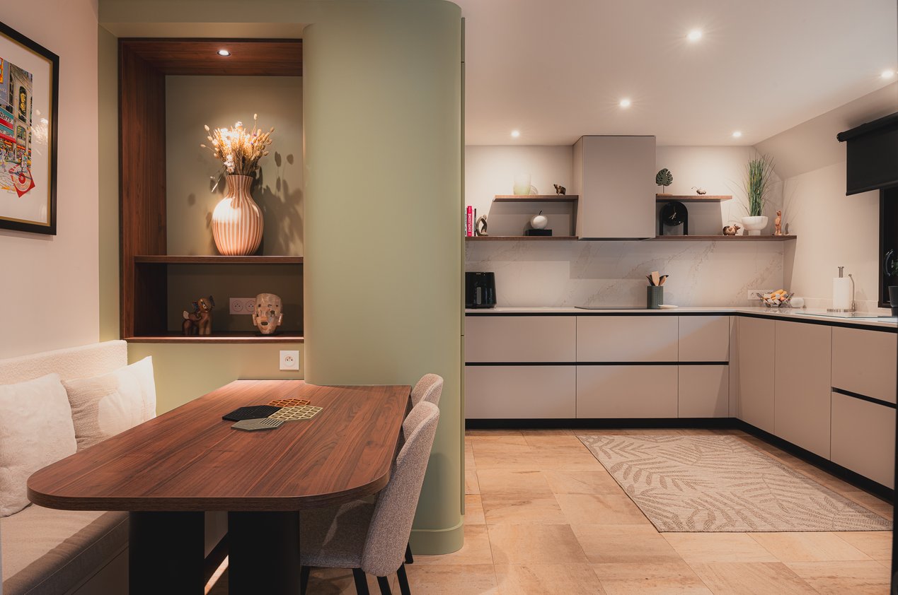 Cuisine ouverte contemporaine avec coin repas sur mesure, niches décoratives en noyer et mobilier intégré réalisé par PERENE Caen.