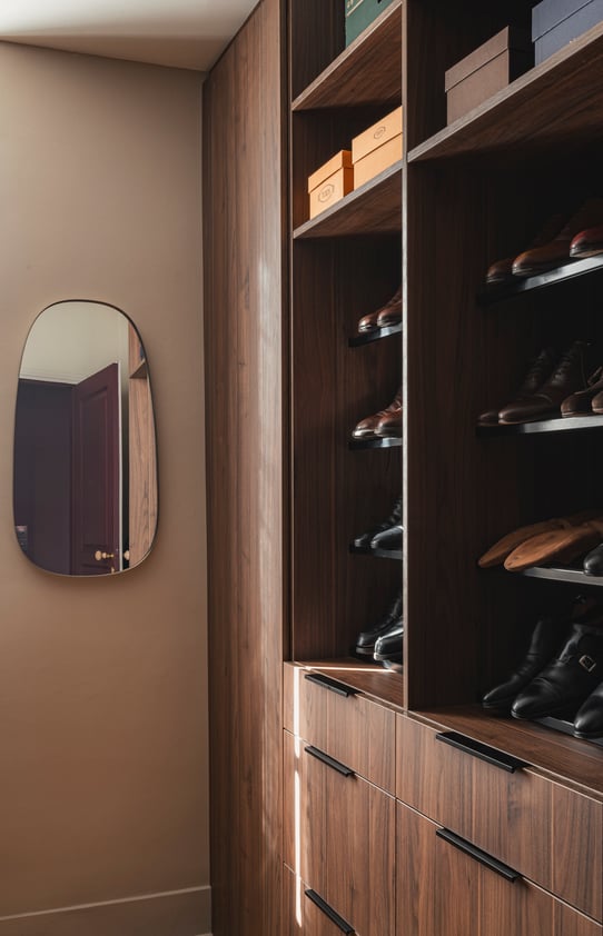 Dressing sur mesure en noyer avec rangements chaussures, miroir et tiroirs intégrés.