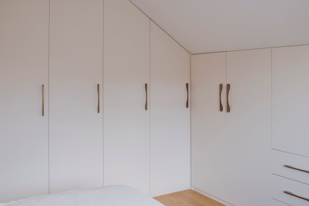 Dressing sous pente façade blanche, poignées en bois