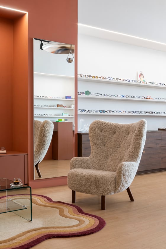Boutique opticien sur mesure fauteuil et tapis, mur terracotta