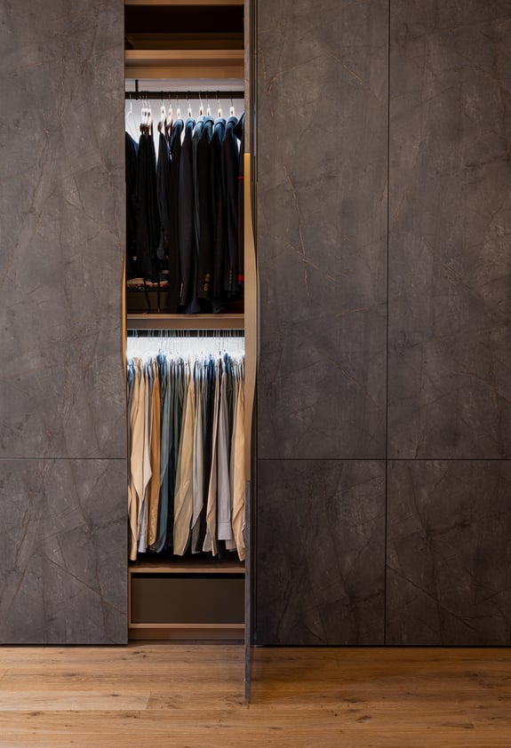 Détail du dressing sur mesure avec penderie intégrée et façades sombres.
