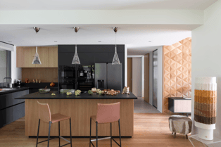 Cuisine sur mesure Perene Réunion avec îlot central noir, façades en bois, mobilier contemporain et électroménager intégré.