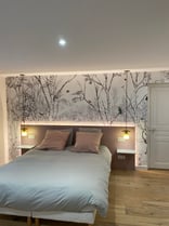 Vue sur le lit dans la chambre avec agencement de la tete de lit 