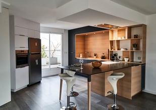 Toute ouverte sur une grande pièce de vie et donnant sur un terrasse, la cuisine s'impose comme l'élément central de la vie familiale.
