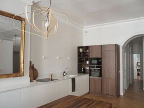 Tout en longueur sur un des murs de la pièce de vie, la cuisine sobre et moderne garde une touche ancienne avec notamment ce trmeau qui avait sa place sur l'ancienne cheminée.