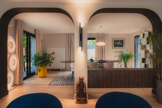 Agencement intérieur contemporain avec arches architecturales, bibliothèque sur mesure et meuble séparatif en noyer réalisé par PERENE Caen.