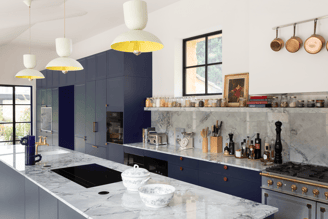 Cuisine sur mesure Perene Réunion avec façades bleu profond, îlot central en marbre, électroménager intégré et finitions haut de gamme.