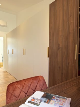 Aménagement sur mesure avec dressing et bureau en bois intégré.