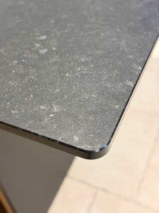 La beauté brute de la pierre naturelle en finition cuir, et ce coin subtilement arrondi qui apporte fluidité et soin du détail — le caractère à l'état pur.