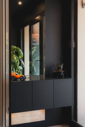 Meuble d’entrée suspendu sur mesure avec miroir intégré et finitions noires réalisé par PERENE Caen.