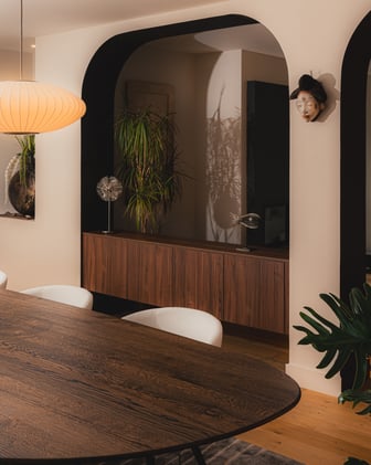 Meuble suspendu en noyer sur mesure intégré sous une arche contemporaine dans un projet d’agencement intérieur réalisé par PERENE Caen.