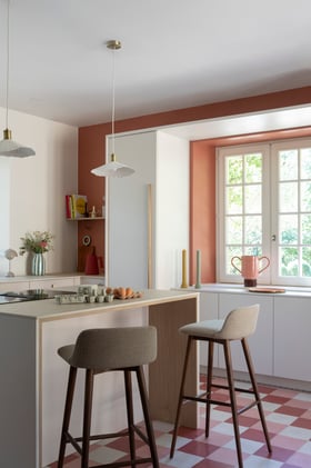 Cuisine terracotta et blanche, sol en damier et tabourets