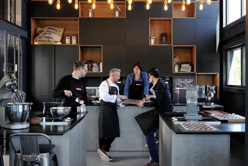 Equipe chocolaterie devant ilot de cuisine industriel