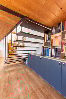 Vue d'ensemble de cet aménagement tout en longueur qui comprend un meuble d'accueil, une banquette en enfilade et enfin une bibliothèque.