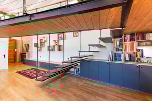 Vue d'ensemble de cet aménagement tout en longueur qui comprend un meuble d'accueil, une banquette en enfilade et enfin une bibliothèque.