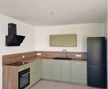Cuisine moderne de Mme C, en L aux tons vert doux et bois, au design épuré, offrant un espace fonctionnel et chaleureux.